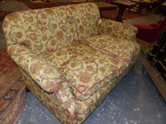 A TWO SEAT SETTEE COVERED IN BEIGE GROUND UPHOLSTERY WORKED WITH COLOURED FLOWERING VINES. 150 x