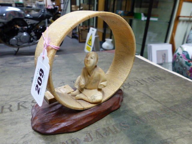 A JAPANESE IVORY FIGURE SEATED WITHIN AN UNFINISHED COOPERED TUB ON IT'S SIDE. H.12cms.