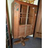 AN INTERESTING ART DECO LIMED AND DECORATED OAK CABINET WITH GLAZED DOOR ON COLUMN SUPPORT AND