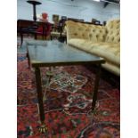 A BRASS LOW TABLE WITH INSET GLASS TOP ON REEDED SUPPORTS. W.100 x H.40cms.