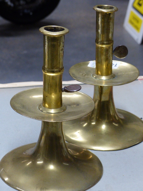 A PAIR OF 18th.C.BRASS CANDLESTICKS WITH IRON EJECTOR RODS IN THE CYLINDRICAL COLUMNS ABOVE THE WIDE