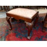 A MAHOGANY QUEEN ANNE STYLE STOOL, THE DROP IN SEAT ON CABRIOLE LEGS CARVED WITH FOLIAGE AT THE