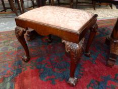 A MAHOGANY QUEEN ANNE STYLE STOOL, THE DROP IN SEAT ON CABRIOLE LEGS CARVED WITH FOLIAGE AT THE