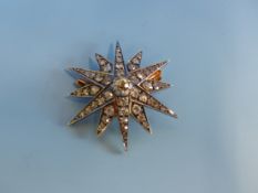 AN ANTIQUE OLD CUT DIAMOND STARBURST BROOCH, THE CENTRAL DIAMOND IS SURROUNDED BY TWELVE RAYS,