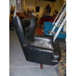 A MID CENTURY WING BACK SWIVEL LOUNGER CHAIR WITH BUTTON BACK REXINE UPHOLSTERY.