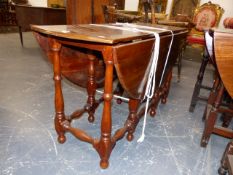 A SOLID YEW WOOD COTTAGE GATELEG SUPPER TABLE ON TURNED LEGS AND STRETCHERS. W.118 x H.69cms.