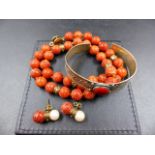 A UNIFORM ROW OF CORAL KNOTTED BEADS INTERSPERSED WITH GOLD RONDELLES AND FINISHED WITH A 9ct GOLD