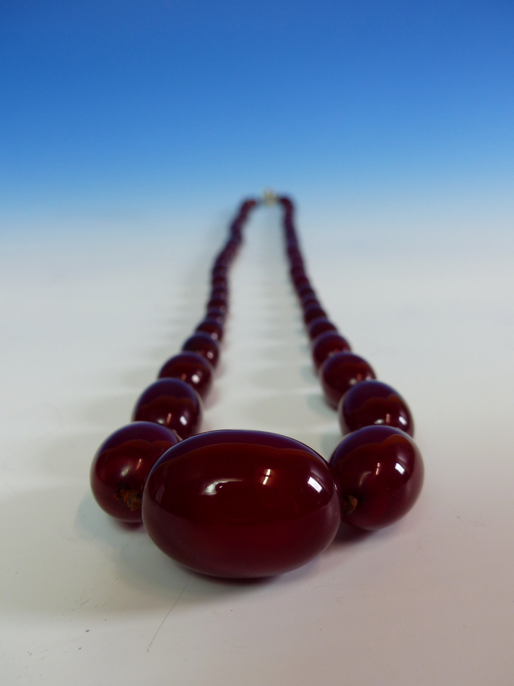 A GRADUATED ROW OF CHERRY AMBER BEADS, KNOTTED. LENGTH 76cms, WEIGHT 60 grams. - Image 12 of 21