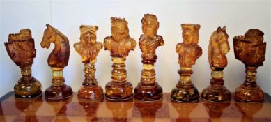 ATTRIBUTED TO WERNER LUX, A BALTIC AMBER CHESS SET IN AMBER CHESSBOARD BOX, THE QUEENS H.9.5cms.