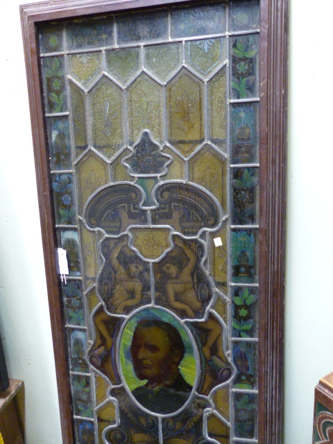 AN OLD STAINED GLASS LEADED PANEL LATER MOUNTED IN A WOODEN FRAME. 67 x 204cms.