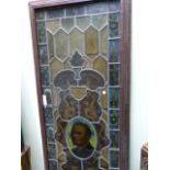 AN OLD STAINED GLASS LEADED PANEL LATER MOUNTED IN A WOODEN FRAME. 67 x 204cms.
