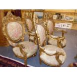 A SET OF FOUR CARVED GILTWOOD ARMCHAIRS TOGETHER WITH A SETTEE, EACH WITH PIERCED FOLIATE