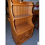 AN ERCOL PALE ELM WATERFALL BOOKCASE WITH CUPBOARD BASE. 61 x 34 x H.101cms.