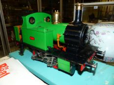 A SCRATCH BUILT LIVE STEAM 0-4-0 LOCOMOTIVE DISPLAYED IN GLAZED CASE.