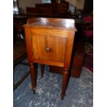 A MAHOGANY BEDSIDE CUPBOARD WITH 3/4 GALLERY TOP, THE TAPERING CYLINDRICAL LEGS ON SPINDLE FEET.