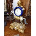 A GILT SILVERED AND BLUE CERAMIC TIMEPIECE SUPPORTED ON THE BACK OF A HORSE. H.43cms.