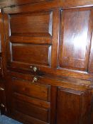 AN OAK DEUDDARN, THE CORNICE WITH PENDANT ENDS OVERHANGING TWO PANELLED DOORS RECESSED ABOVE THE