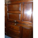 AN OAK DEUDDARN, THE CORNICE WITH PENDANT ENDS OVERHANGING TWO PANELLED DOORS RECESSED ABOVE THE