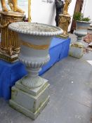 A PAIR OF ANTIQUE CAST IRON CAMPAGNA GARDEN URNS OF RIBBED FORM AND PLINTH BASES. OVERALL H.105cms.