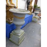 A PAIR OF ANTIQUE CAST IRON CAMPAGNA GARDEN URNS OF RIBBED FORM AND PLINTH BASES. OVERALL H.105cms.