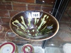 A CHINESE TRUNCATED CONICAL BOWL, THE TREACLE BLACK GLAZED SPLASHED AND STREAKED IN GREEN. Dia.14.