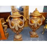 A PAIR OF GILT LIDDED FORM BALUSTER NEO CLASSICAL STYLE URNS, SWAGGED FROM MERMAID HANDLES.