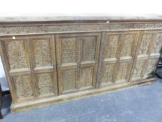 AN INDIAN HARDWOOD CABINET WITH FOUR PANELLED DOORS CARVED WITH BIRDS AND FOLIAGE BELOW A CORNICE