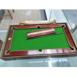 A NUKU PINE BOXED MAHOGANY MINIATURE BILLIARD TABLE, SCOREBOARD, SPRING LOADED METAL CUE, RED AND