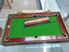 A NUKU PINE BOXED MAHOGANY MINIATURE BILLIARD TABLE, SCOREBOARD, SPRING LOADED METAL CUE, RED AND