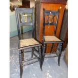 A PAIR OF ANTIQUE EBONISED LYRE BACKED CORRECTION CHAIRS WITH CANED SEATS