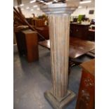 A CARVED AND PAINTED COLUMN FORM PEDESTAL WITH OCTAGONAL TOP ABOVE FLUTED SHAFT AND PLINTH BASE. H.