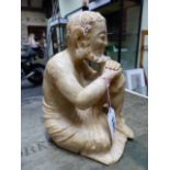 AN ORIENTAL ALABASTER FIGURE OF A BEARDED MONK SEATED WITH HIS CHIN RESTING ON HAND FOLDED ON A