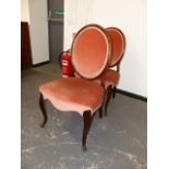 A PAIR OF ANTIQUE CARVED MAHOGANY FRENCH HEPPLEWHITE STYLE SALON CHAIRS WITH OVAL BACKS AND SCROLL