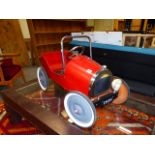 A VINTAGE STYLE RED PAINTED TIN PLATE PEDAL CAR. L.83cms.