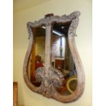 AN ANTIQUE CARVED LIMED OAK LYRE FORM FRAMED WALL MIRROR. W.130 x H.152cms.