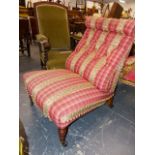 A VICTORIAN BUTTON BACK PINK CHEQUER UPHOLSTERED NURSING CHAIR WITH TURNED FRONT LEGS ON BLACK