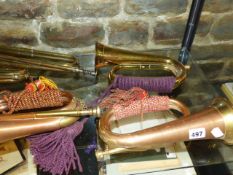 FOUR BRASS MOUNTED COPPER BUGLES AND TWO LARGER, THE FORMER WITH CORD AND TASSEL REGIMENTAL BINDINGS