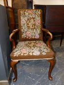 A QUEEN ANNE STYLE WALNUT ARMCHAIR WITH NEEDLEWORK BROWN GROUND FLORAL ENCLOSED CRESTED BACK AND