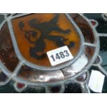 A LEADED GLASS ARMORIAL ROUNDEL WITH A CROWNED LION RAMPANT WITHIN BERRIED LEAVES. Dia.24.5cms.