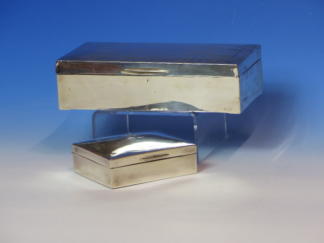 A SILVER HALLMARKED WOOD LINED CIGARETTE BOX, TOGETHER WITH A SMALLER SIMILAR EXAMPLE. LARGER