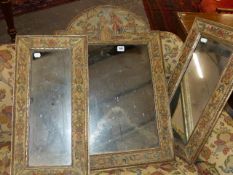 THREE FOLD MIRRORS WITH FLORAL NEEDLEWORK ENCLOSED BY GILT GESSO EDGES.