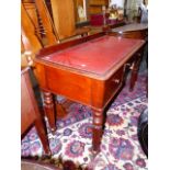 A VICTORIAN MAHOGANY WRITING TABLE WITH THREE DRAWERS OVER TURNED AND REEDED LEGS ON BRASS