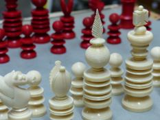 AN ENGLISH TURNED IVORY CHESS SET, THE PIECES IN RED AND WHITE, THE KINGS H.10cms.
