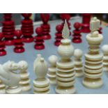 AN ENGLISH TURNED IVORY CHESS SET, THE PIECES IN RED AND WHITE, THE KINGS H.10cms.