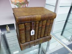 A PAIR OF DECANTERS HOUSED IN A BOX FORMED FROM FRENCH LEATHER BOUND BOOKS. 30 x 30 x 21.5cms.