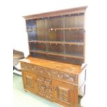 A GOOD 17th.C. STYLE OAK DRESSER WITH PLATE RACK OVER THREE DRAWERS, TWO PANEL DOORS AND THREE