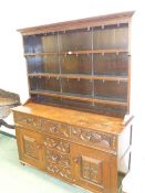 A GOOD 17th.C. STYLE OAK DRESSER WITH PLATE RACK OVER THREE DRAWERS, TWO PANEL DOORS AND THREE