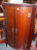 A GEO.III.OAK BOW FRONT WALL HANGING CORNER CABINET WITH SHELVED INTERIOR. W.68 x H.92cms.