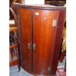 A GEO.III.OAK BOW FRONT WALL HANGING CORNER CABINET WITH SHELVED INTERIOR. W.68 x H.92cms.