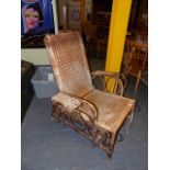 AN ANTIQUE DRYAD TYPE RATTAN RECLINING TERRACE CHAIR WITH PULL OUT FOOTREST.